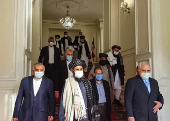 An image shows former Iranian Foreign Minister Mohammad Javad Zarif meeting with Taliban official Mullah Abdul Ghani Baradar in Tehran last year