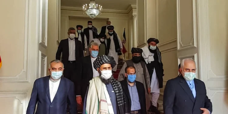 An image shows former Iranian Foreign Minister Mohammad Javad Zarif meeting with Taliban official Mullah Abdul Ghani Baradar in Tehran last year