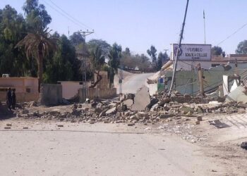 Security personnel stand beside a destroyed security post on Feb. 3, 2022 following overnight attacks by militants on security camps in Naushki district of Balochistan province. (AFP Photo)