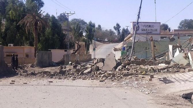 Security personnel stand beside a destroyed security post on Feb. 3, 2022 following overnight attacks by militants on security camps in Naushki district of Balochistan province. (AFP Photo)