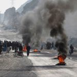 TOPSHOT – Members of Shiite Hazara community burn tyres during a protest after the killing of 11 workers of their community, in Quetta on January 3, 2021. (Photo by BANARAS KHAN/AFP via Getty Images)