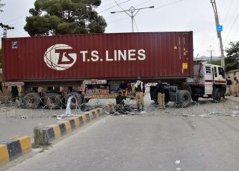 Police officers guard a road blocked by a shipping container and truck in Quetta, the capital of Balochistan province in Pakistan, July 29, 2024.